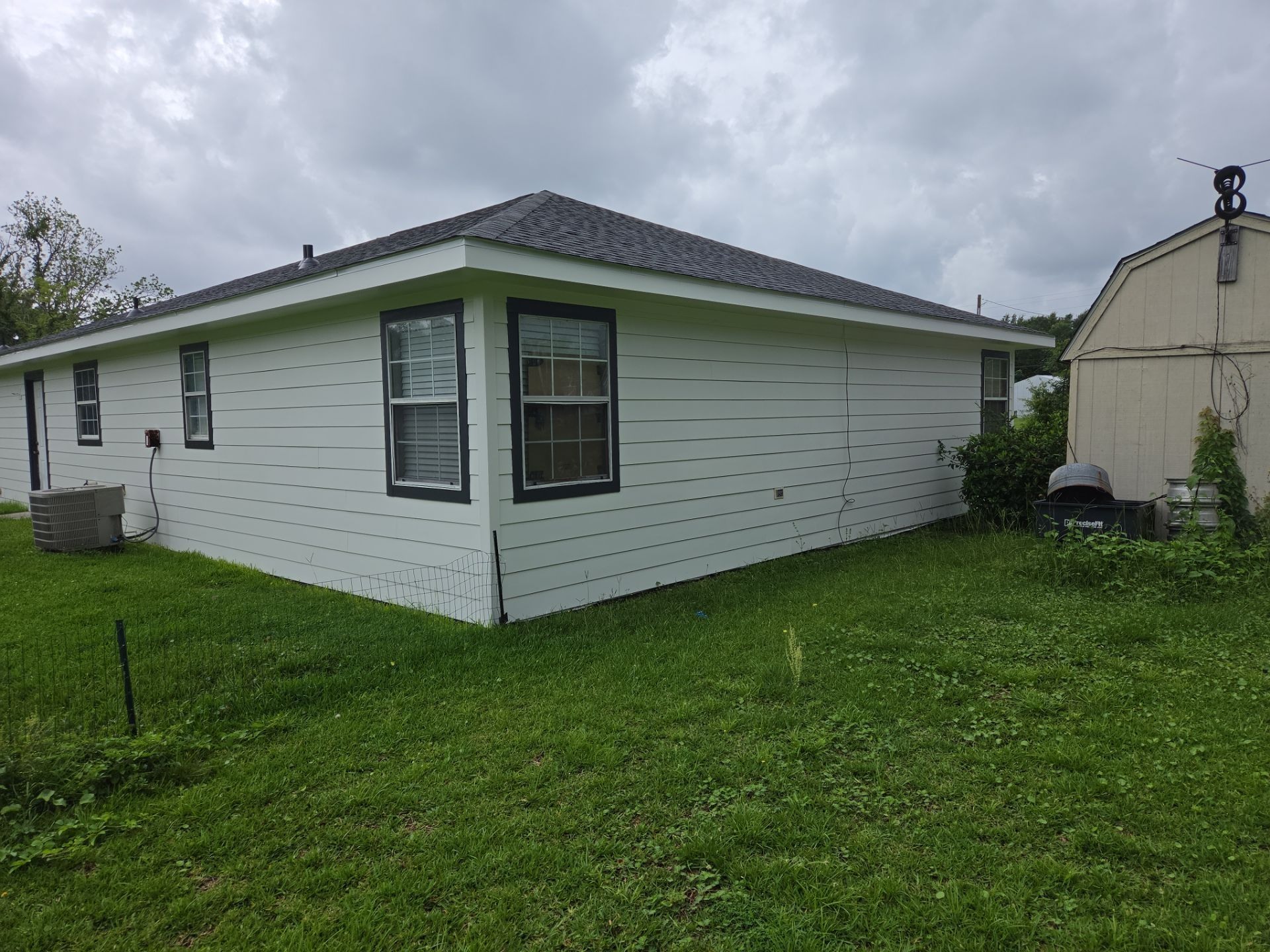 Home exterior with fresh light lap siding and black window trim on a GD Construction job